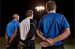 Soccer players standing in line on pitch at night