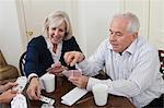 Mature woman and senior man playing cards