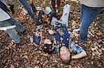 Friends throwing autumn leaves on couple