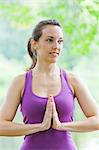 Mid adult woman performing yoga prayer pose by river