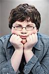 Portrait of young teenage boy with hands on chin