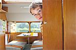 Boy peeking round door in caravan