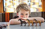 Boy playing with toy plastic horse in caravan