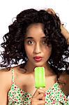 Young woman eating green popsicle, portrait