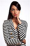 Young woman in striped top looking shocked against white background