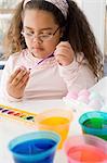 Girl painting an egg for easter