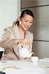 Businesswoman pouring tea