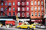 Traditional red brick buildings with old car and firetruck on street in the trendy Chelsea district, Manhattan, New York City, NY, USA