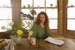 Woman drinking coffee at kitchen table