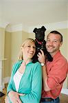 Smiling couple with dog in new home