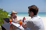 Couple eating together on deck at beach