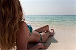 Woman relaxing in sand on beach