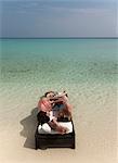 Couple relaxing on daybed at beach