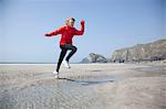 Boy jumping over pools on beach