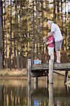 Boy fishing with grandfather in lake