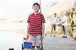 Boy carrying fishing rod on jetty