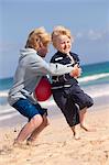 Boys playing with red ball on beach