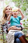 Mother holding son with slice of melon