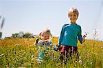 Children walking in field of flowers