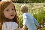 Children walking in field of flowers