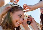 Women placing daisy crown on bride