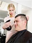 Hairdresser spritzing man's hair