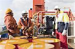 Workers talking on oil rig