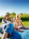 Father laying with daughters outdoors