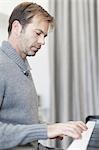 Man playing piano in living room