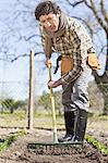 Man turning over soil in garden