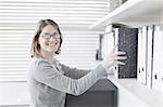 Businesswoman holding binder in office