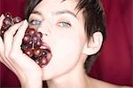 Close up of woman eating bunch of grapes