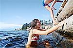 Teenage girls climbing pier