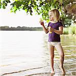 Girl blowing bubbles by lake