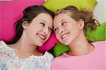 Smiling girls laying on pillows together