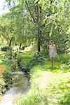 Girl picking flowers by river