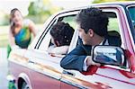 Teenage girl in gown pushing car