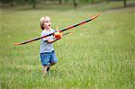 Boy playing with toy airplane outdoors