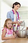 Mother and daughter baking in kitchen