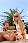 Couple relaxing by swimming pool