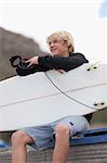 Teenage boy with surfboard on beach