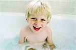 Smiling boy sitting in bath