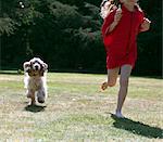 Girl playing with dog in backyard