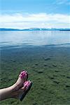 Woman dangling feet over still lake
