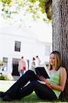 Student reading in grass on campus