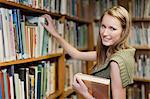 Student selecting books in library