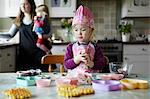 Toddler girl baking in kitchen