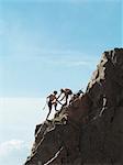 Rock climbers scaling steep rock face