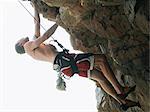 Rock climber scaling steep rock face