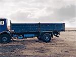 Blue truck parked in dry field